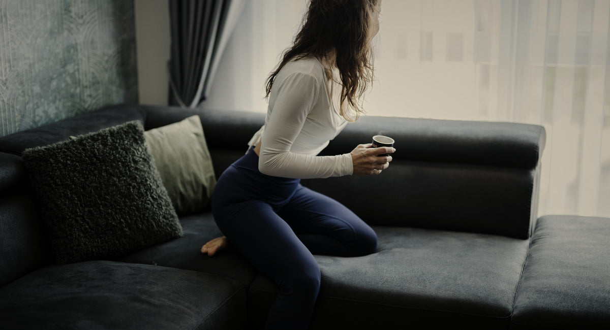 Mujer relajándose junto a la ventana con una taza de té